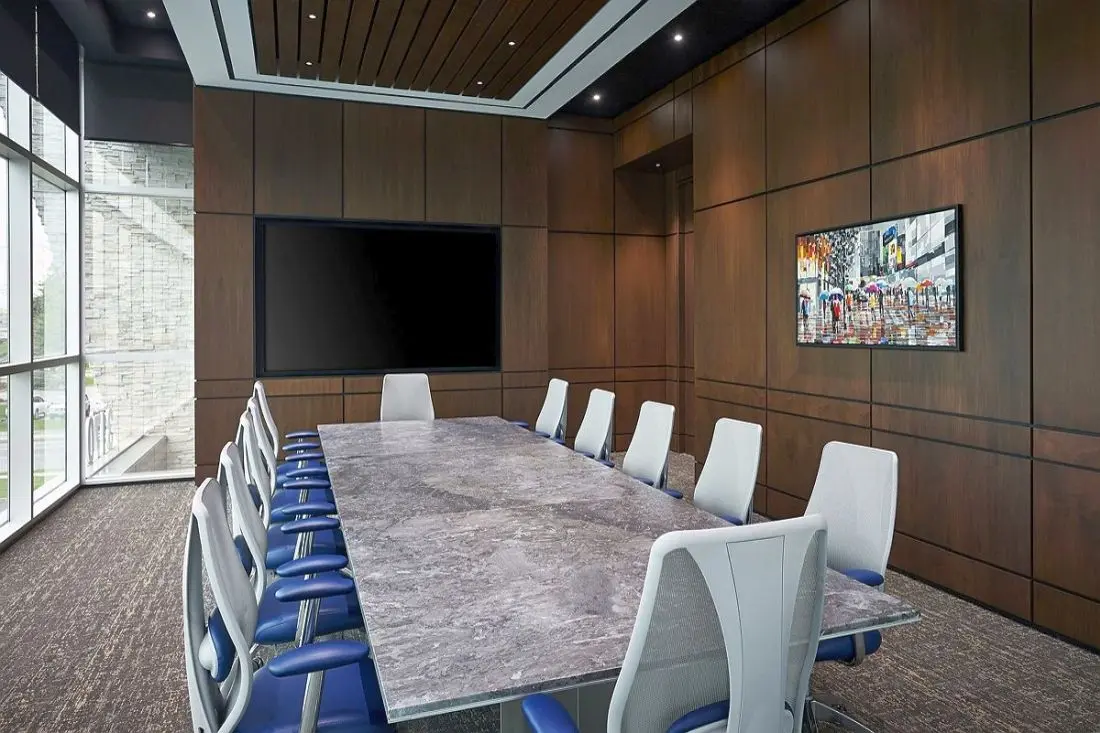 Executive conference room with custom wood millwork by Homestead Woodworks, featuring large windows, a long conference table, and modern chairs